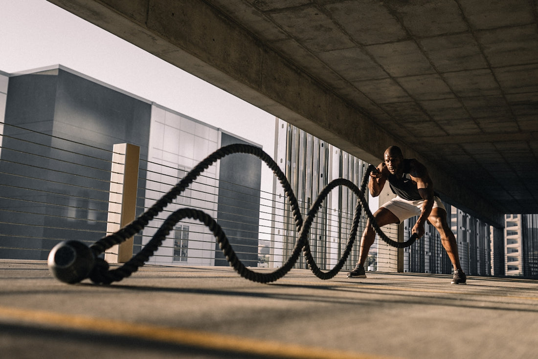 man exercising with battle ropes outdoors