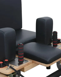 Foldable oak reformer from Gym Gear featuring adjustable straps and padded carriage for versatile Pilates workouts.