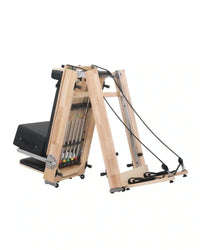 Foldable oak reformer by Gym Gear with padded carriage and adjustable resistance for versatile Pilates workouts.